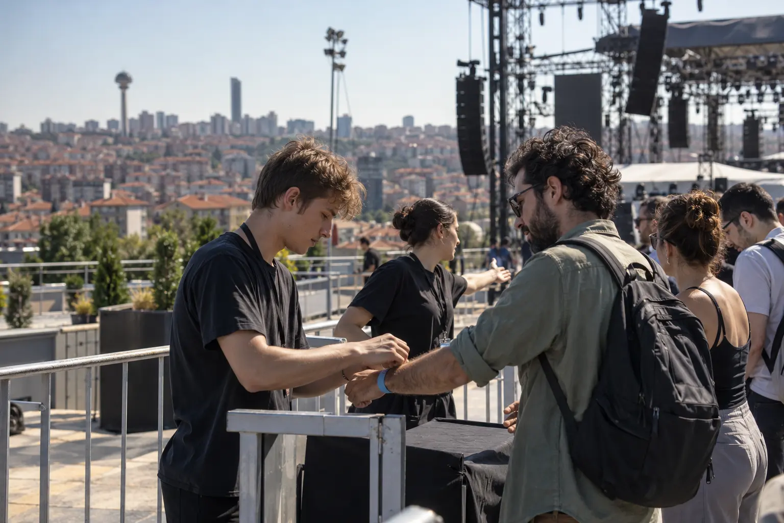 Ankara’da açık hava konserinin girişinde genç bir görevli ziyaretçinin bilekliğini kontrol ediyor.