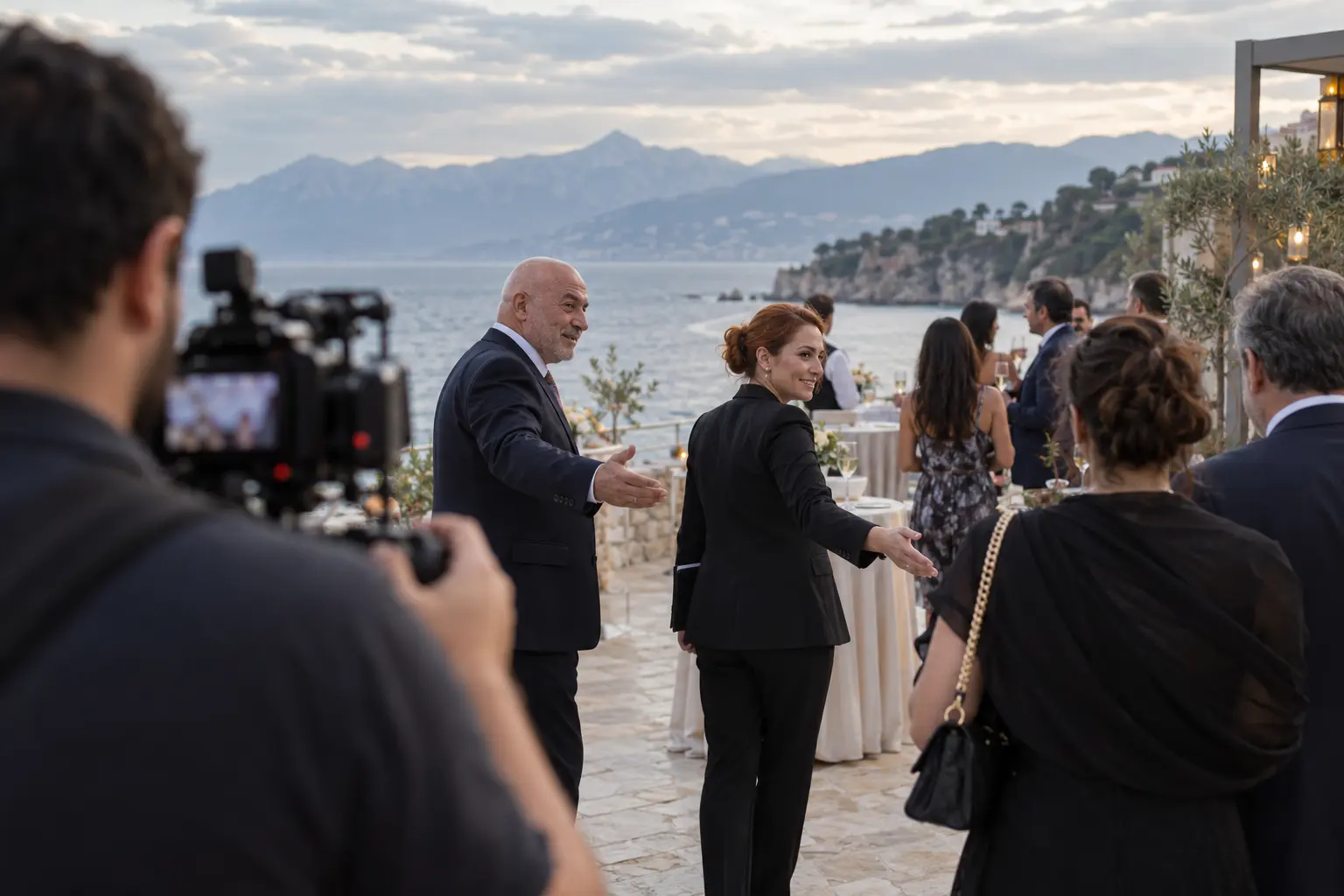 Antalya’da deniz manzaralı otel terasında host ve hostes etkinlik konuklarını yönlendiriyor.